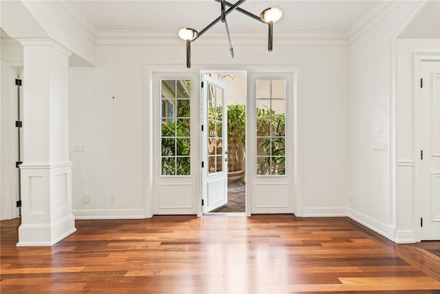 121 Palm Island Ln, Vero Beach, FL 32963 - doorway featuring wood finished floors, plenty of natural light, ornate columns, and ornamental molding