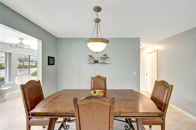 dining space featuring light tile patterned floors and a textured ceiling