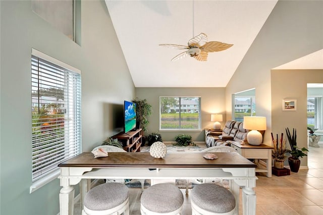 tiled dining area with high vaulted ceiling and ceiling fan