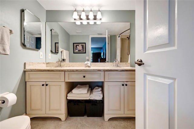 bathroom with tile patterned flooring, vanity, and toilet