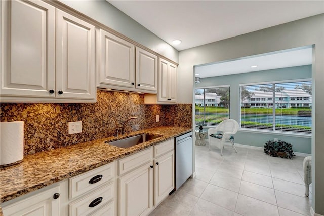 kitchen with light stone countertops, dishwasher, sink, tasteful backsplash, and light tile patterned floors