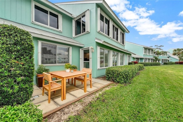 rear view of house featuring a yard and a patio