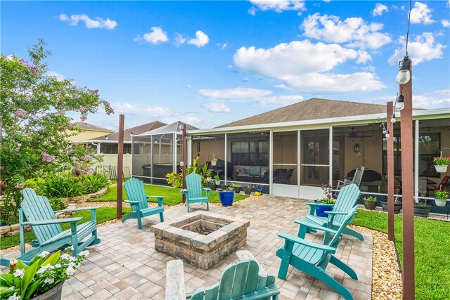 view of patio with glass enclosure, a sunroom, and a fire pit