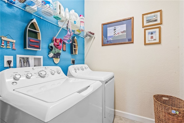 laundry area with separate washer and dryer and light tile patterned floors