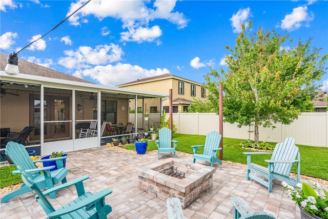 view of patio with an outdoor fire pit and a sunroom