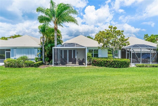 1135 Saint Georges Ln, Vero Beach, FL 32967 - back of property featuring a yard, glass enclosure, and a tile roof