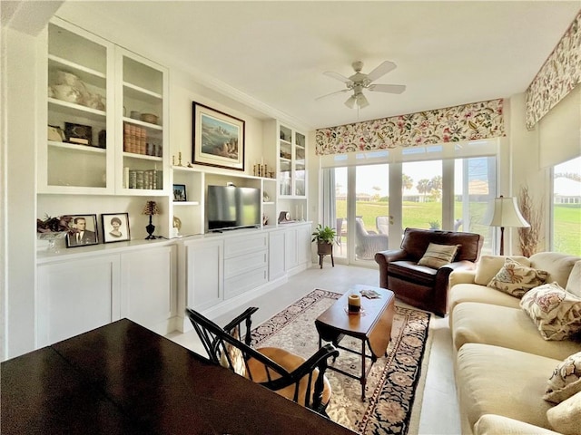 living room featuring ceiling fan and built in shelves