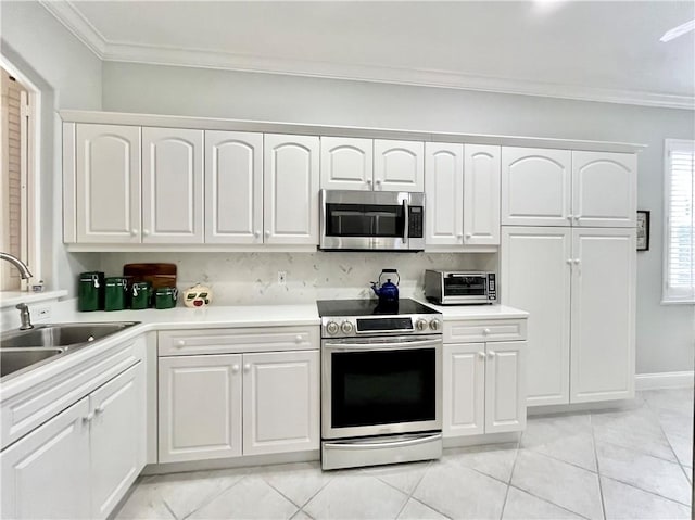 kitchen featuring crown molding, appliances with stainless steel finishes, sink, and white cabinets