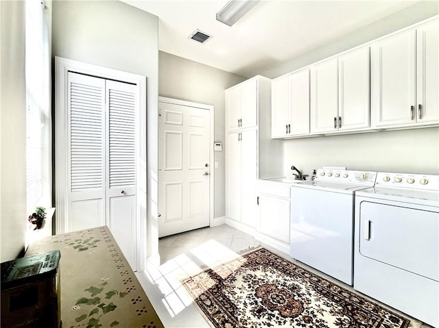 laundry room with cabinets, sink, washing machine and dryer, and light tile patterned floors