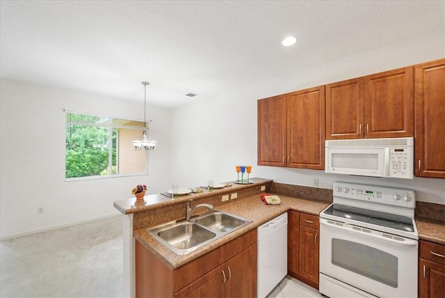 2597 Stockbridge Sq SW Unit 2597, Vero Beach, FL 32962 - kitchen featuring white appliances, a sink, a peninsula, decorative light fixtures, and light colored carpet