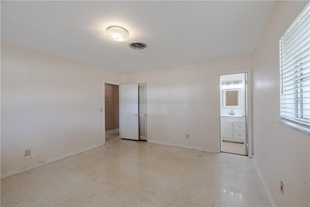 1936 5th Ave, Vero Beach, FL 32960 - unfurnished bedroom with speckle patterned floor and ensuite bathroom