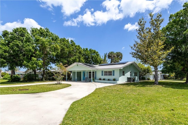 1936 5th Ave, Vero Beach, FL 32960 - ranch-style home featuring concrete driveway, a front yard, and solar panels