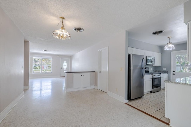 1936 5th Ave, Vero Beach, FL 32960 - kitchen featuring appliances with stainless steel finishes, open floor plan, a chandelier, white cabinetry, and healthy amount of natural light