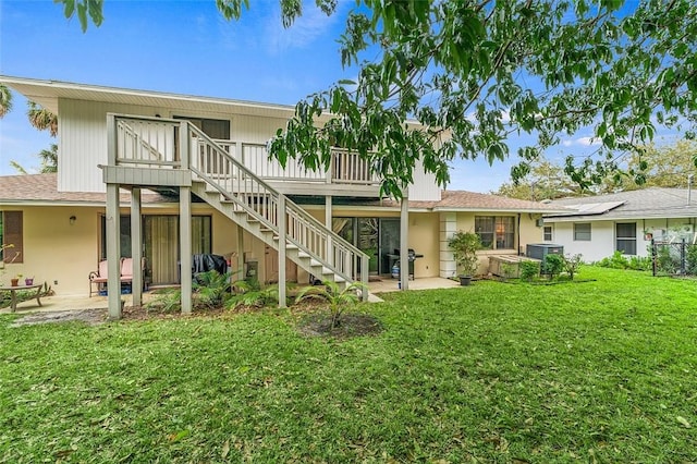 back of house featuring a wooden deck, a yard, central AC, and a patio