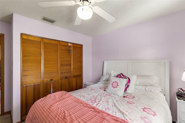 bedroom with ceiling fan, a closet, and a textured ceiling