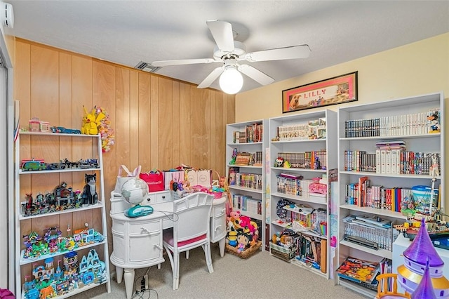 rec room featuring wood walls, ceiling fan, and carpet