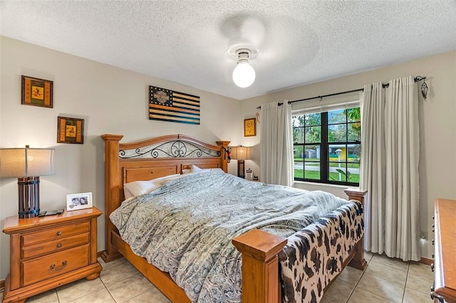 bedroom with a textured ceiling and light tile patterned floors