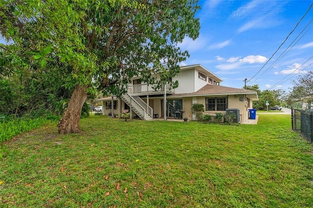 back of house featuring a wooden deck and a lawn