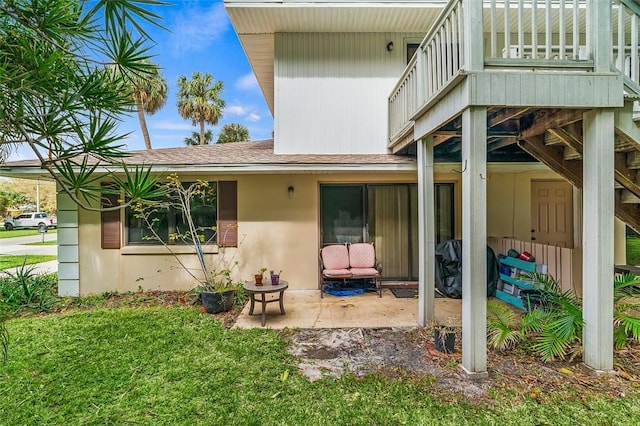 rear view of house featuring a balcony, a yard, and a patio area