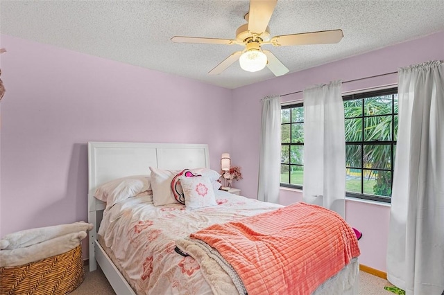 bedroom featuring ceiling fan, carpet floors, and a textured ceiling