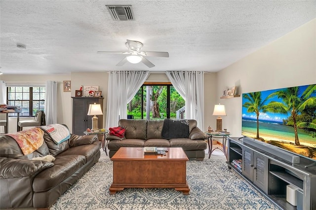 living room featuring a textured ceiling and ceiling fan