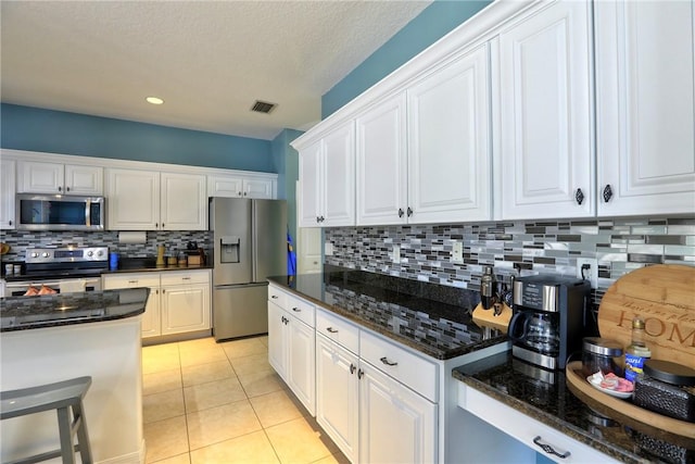 537 Ray St, Sebastian, FL 32958 - kitchen featuring visible vents, decorative backsplash, white cabinetry, dark stone countertops, and appliances with stainless steel finishes