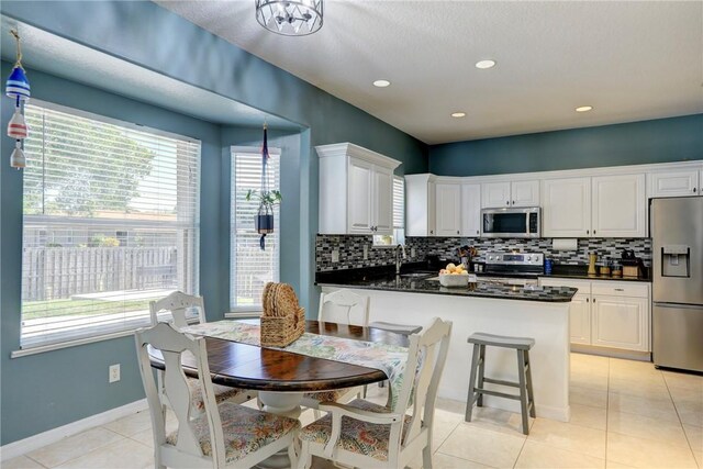 537 Ray St, Sebastian, FL 32958 - kitchen featuring stainless steel appliances, dark countertops, white cabinetry, and tasteful backsplash
