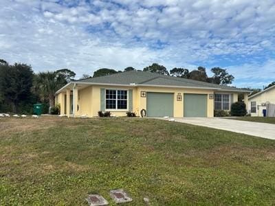 single story home featuring a front yard and a garage