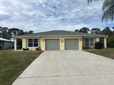 ranch-style house featuring a front lawn and a garage