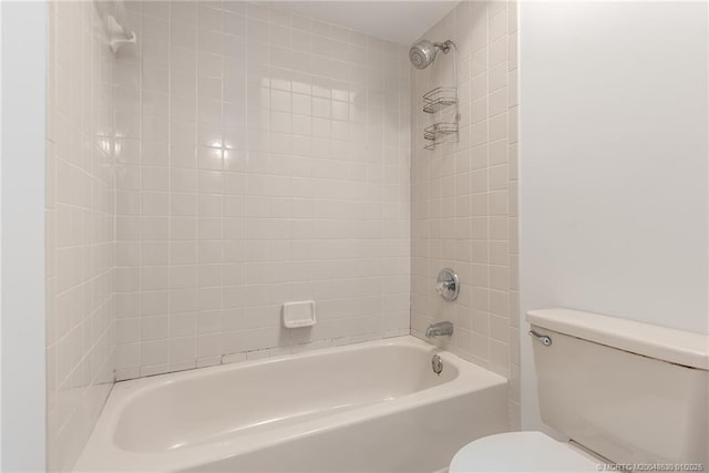 bathroom featuring toilet and tiled shower / bath combo