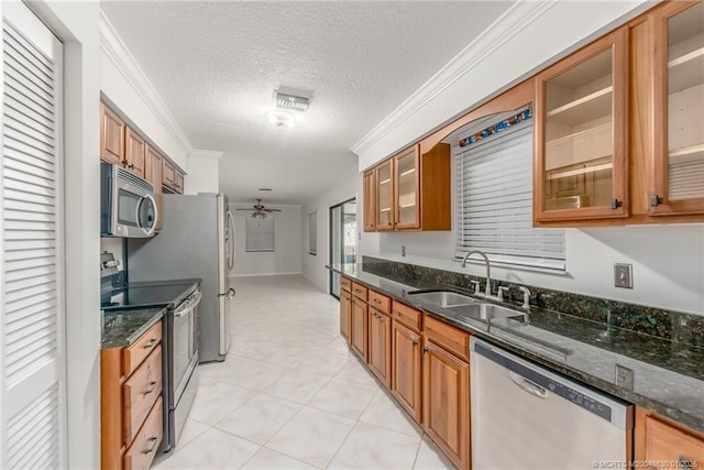 kitchen featuring a textured ceiling, stainless steel appliances, dark stone countertops, and sink