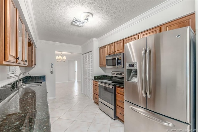 kitchen with light tile patterned flooring, sink, stainless steel appliances, ornamental molding, and dark stone counters