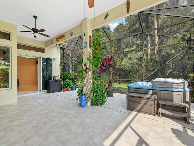 view of patio / terrace featuring a lanai, ceiling fan, and a hot tub