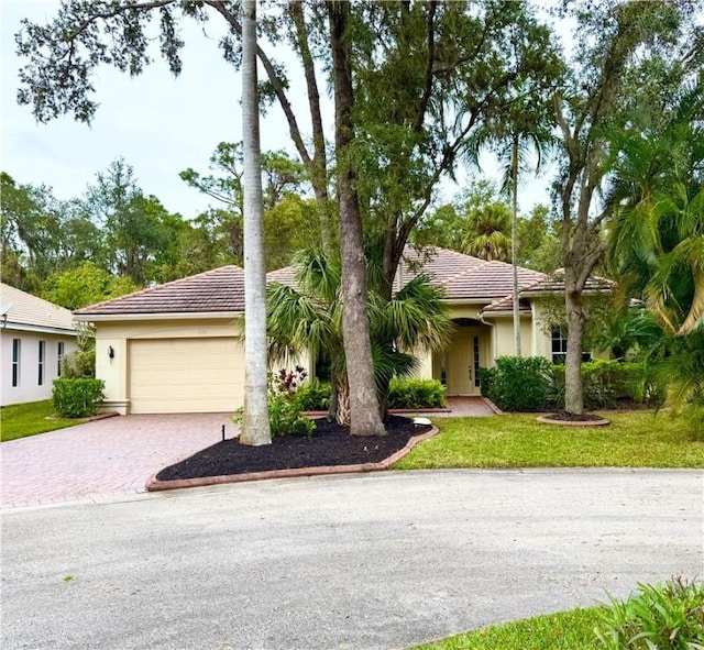 ranch-style house featuring a garage and a front lawn