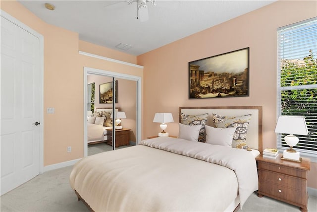 carpeted bedroom with ceiling fan and a closet