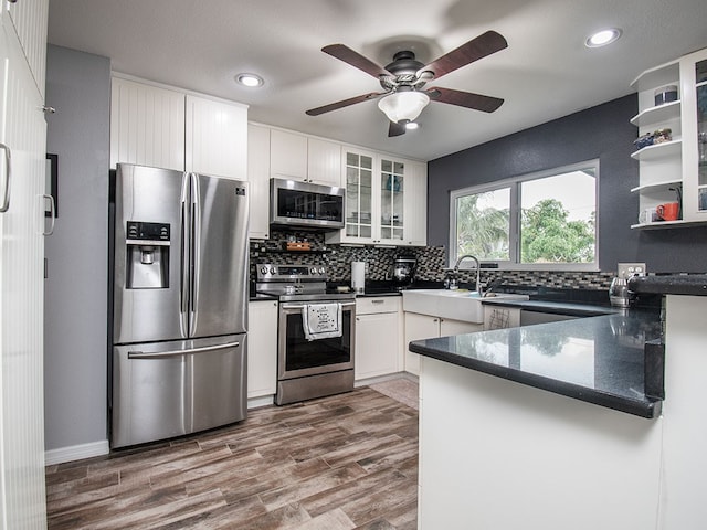 624 24th St SW, Vero Beach, FL 32962 - kitchen with appliances with stainless steel finishes, decorative backsplash, a ceiling fan, glass insert cabinets, and white cabinetry