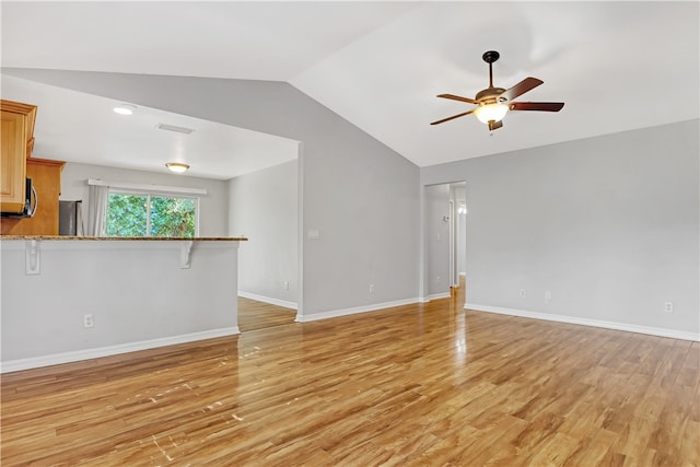 unfurnished living room with light hardwood / wood-style flooring, ceiling fan, and vaulted ceiling