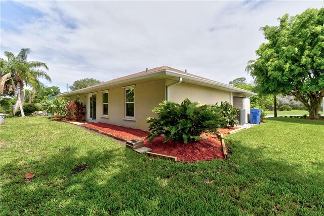 3405 Atlantic Blvd, Vero Beach, FL 32960 - view of side of property featuring stucco siding, a lawn, and cooling unit