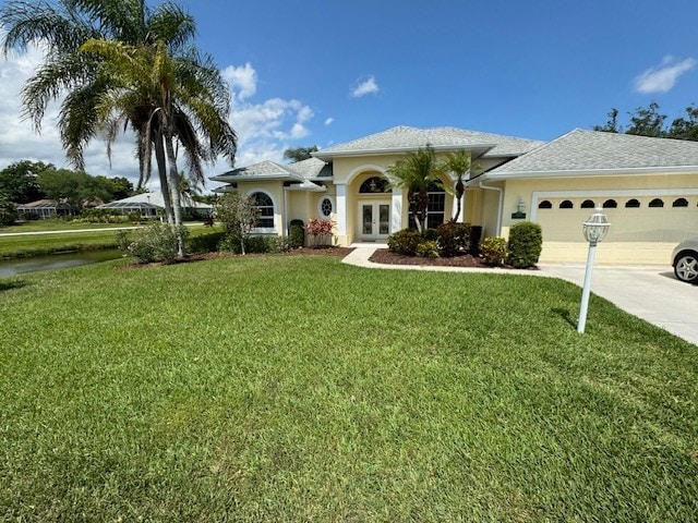 mediterranean / spanish-style home featuring french doors, a garage, and a front lawn