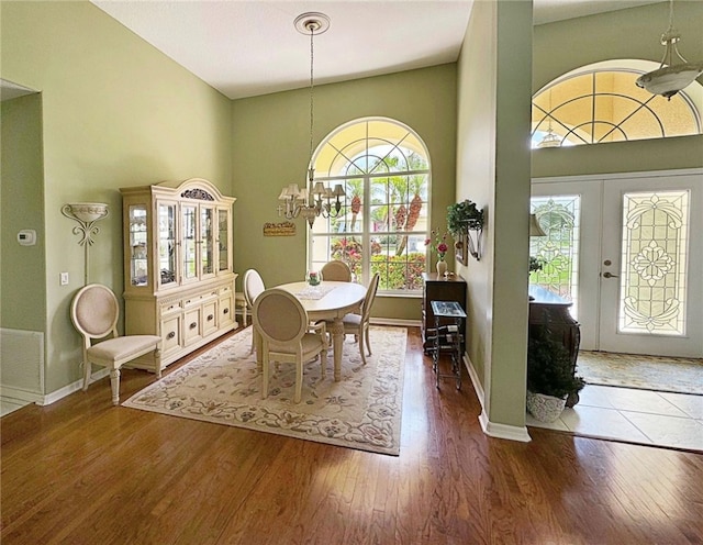 dining area featuring a notable chandelier, dark hardwood / wood-style floors, plenty of natural light, and french doors