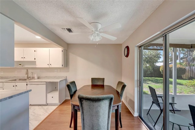 dining space with a healthy amount of sunlight, light wood finished floors, and visible vents