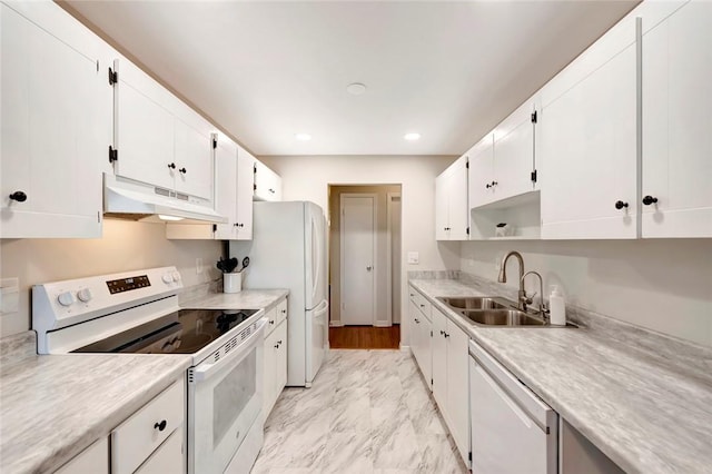 kitchen featuring under cabinet range hood, white appliances, a sink, white cabinetry, and marble finish floor