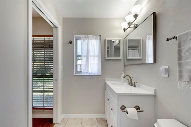 bathroom featuring toilet, vanity, baseboards, and tile patterned floors