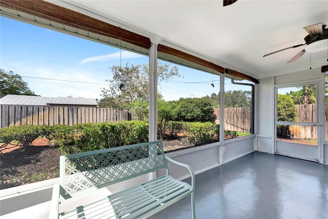 unfurnished sunroom with a ceiling fan