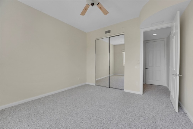 unfurnished bedroom with a closet, light carpet, and ceiling fan