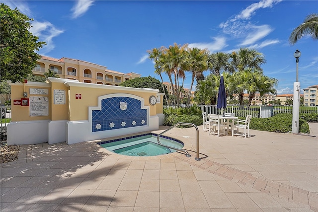 view of pool with a hot tub and a patio area