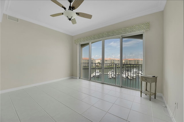 spare room featuring a water view, light tile patterned floors, crown molding, and ceiling fan