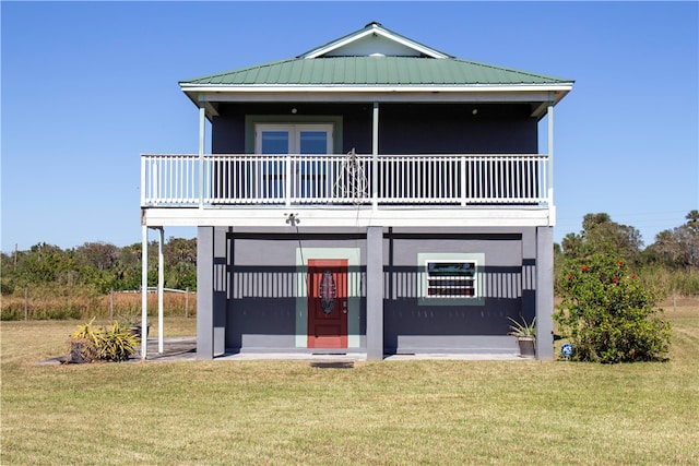 view of front of house with a balcony and a front yard