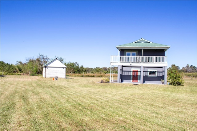 back of house with a balcony, a storage unit, and a lawn