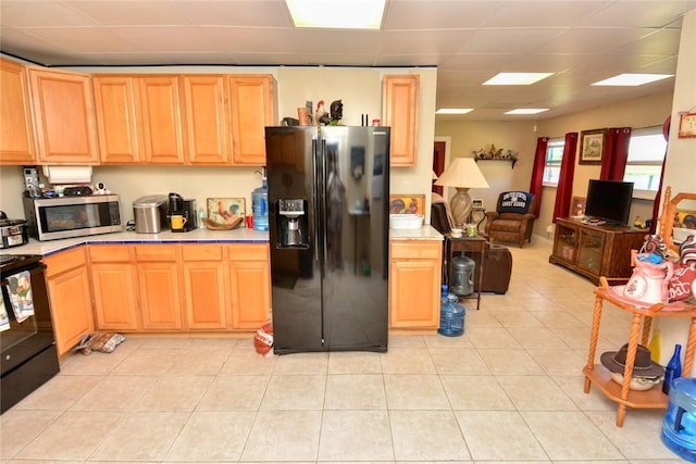 kitchen with black appliances, light brown cabinets, and light tile patterned floors